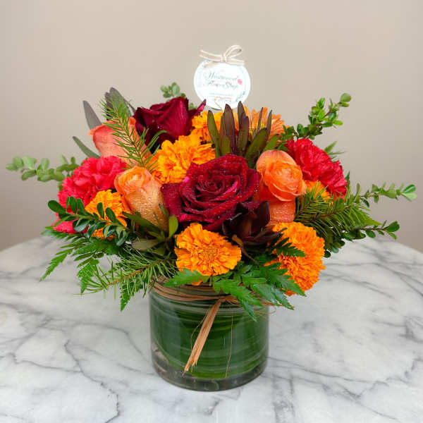 Bouquet of red and orange flowers in a glass vase