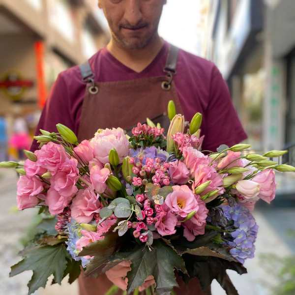Handheld bouquet of pink and lavender flowers with lilies