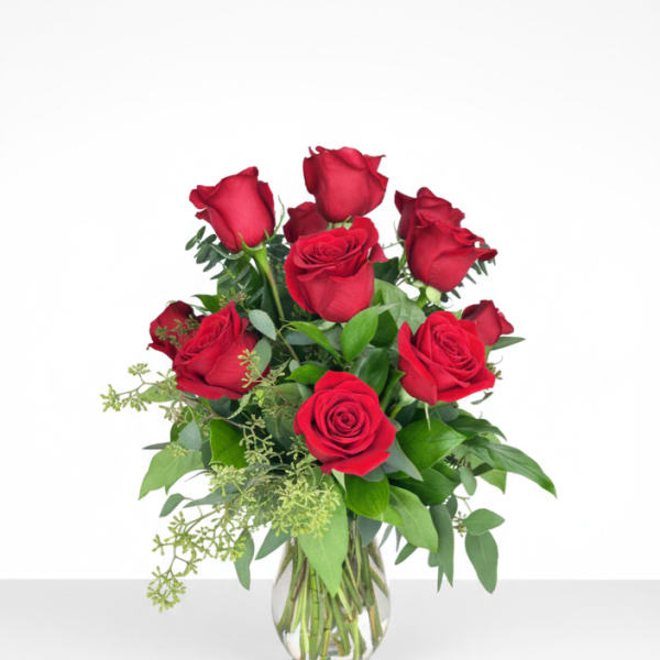 Red roses arranged in a clear glass vase