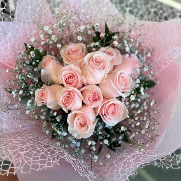 Bouquet of pale pink roses wrapped in pink paper