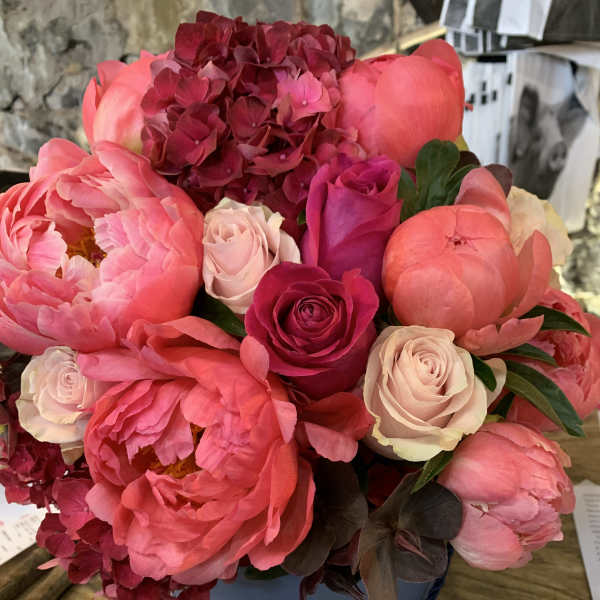 Artistically arranged peonies and hydrangea in a Tiffany hat box