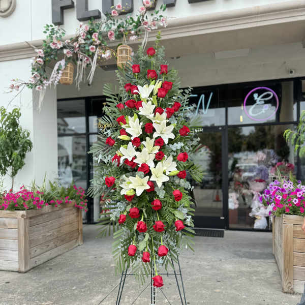 Tall standing floral spray with red roses and white lilies on a metal easel