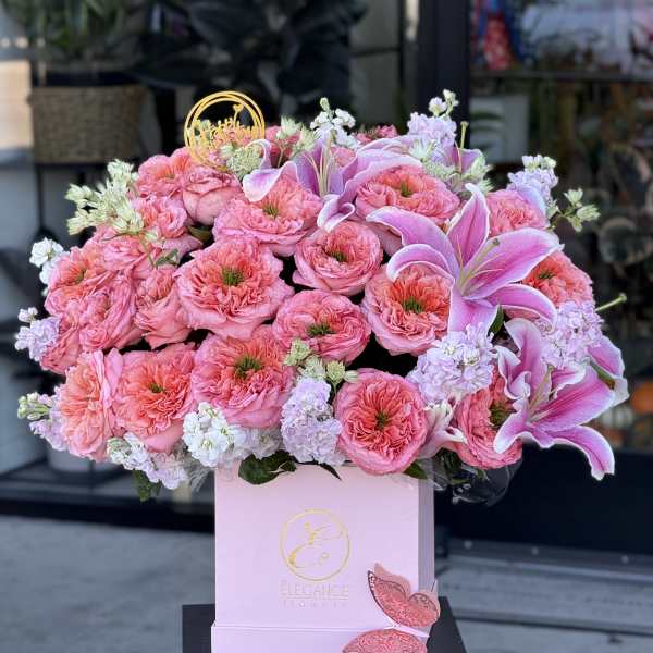 Pink roses and lilies arranged in a pink box