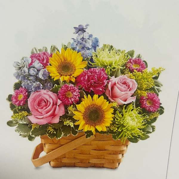 Basket arrangement with pink roses, sunflowers, and mixed blooms