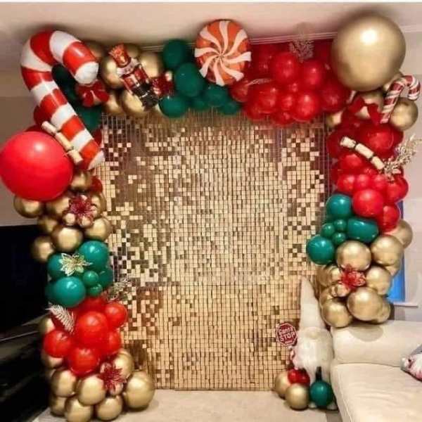 Christmas balloon arch with candy cane and ornament shapes around a gold backdrop