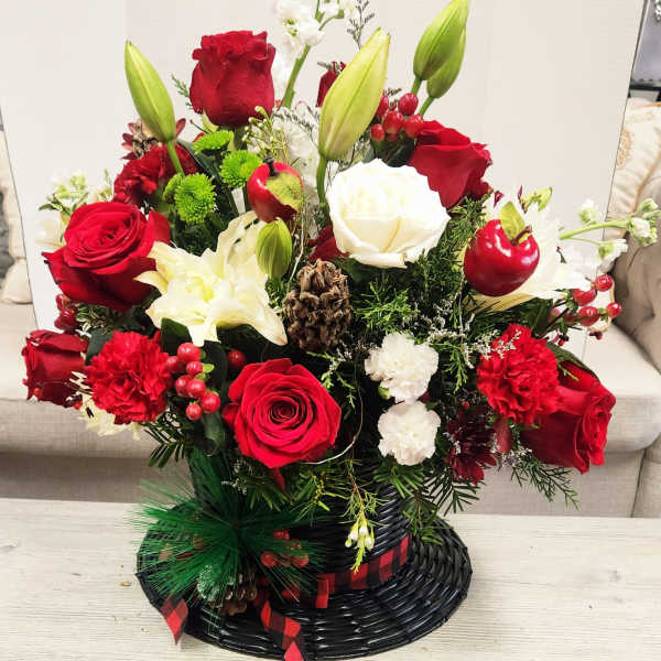 Red and white floral arrangement in a black basket with ribbon