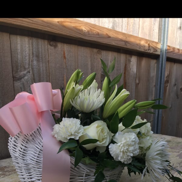 White floral basket with pink ribbon and lilies, roses, and chrysanthemums