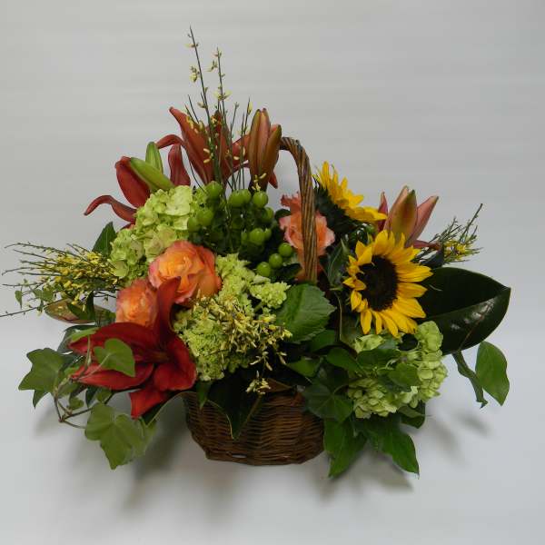 Basket arrangement with sunflowers, lilies, and roses