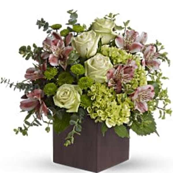 Green and pink floral arrangement in a dark square box