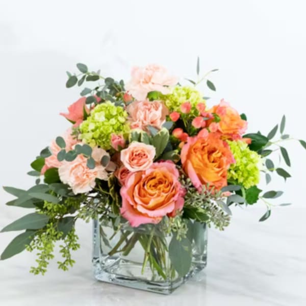 Bouquet of peach and orange roses in a clear glass vase