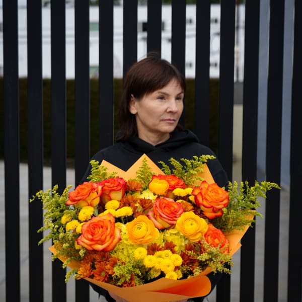 Large bouquet of orange and yellow roses with small yellow flowers
