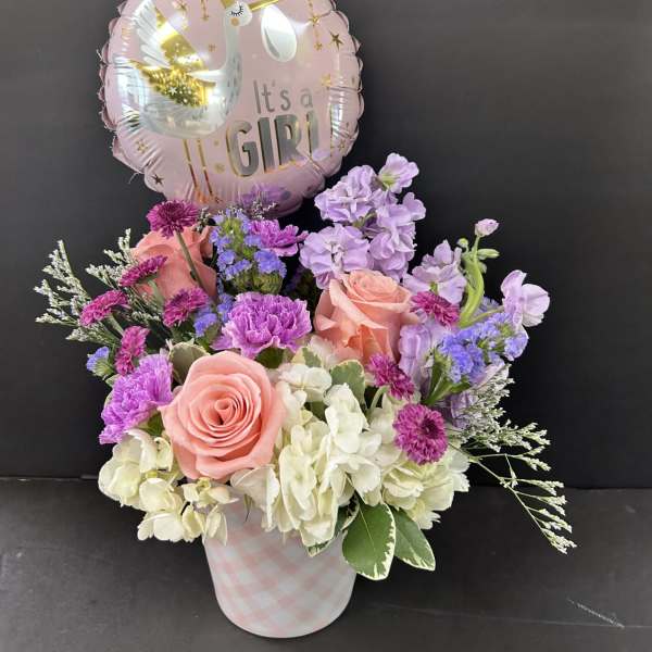 Pink and lavender flower arrangement with a "It's a Girl" balloon