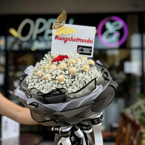 Bouquet of white baby's breath with gold-wrapped chocolates and a red rose