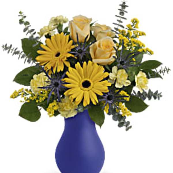 Yellow and cream flower arrangement in a blue vase