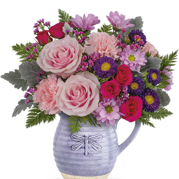 Pink and purple flower arrangement in a lavender pitcher vase
