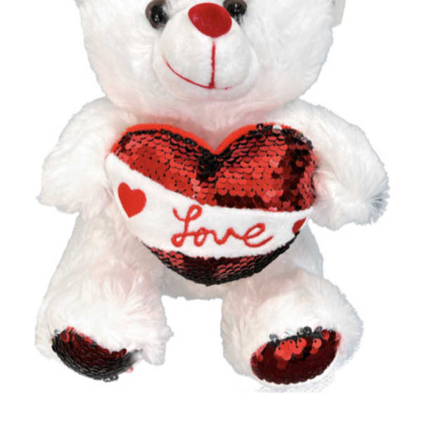 White teddy bear holding a red sequined heart with the word Love