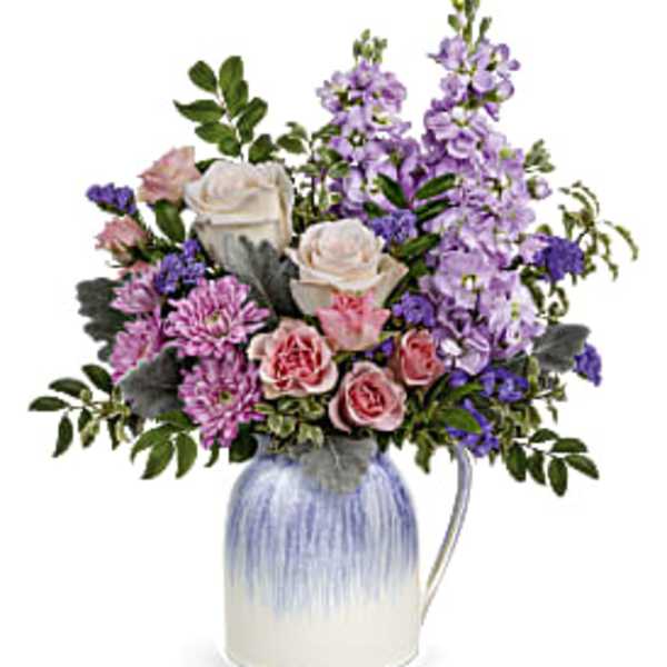 Bouquet of pink and lavender flowers in a blue-and-white pitcher vase