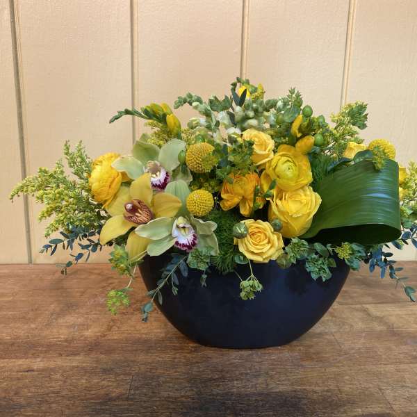 Yellow floral arrangement in a black bowl vase