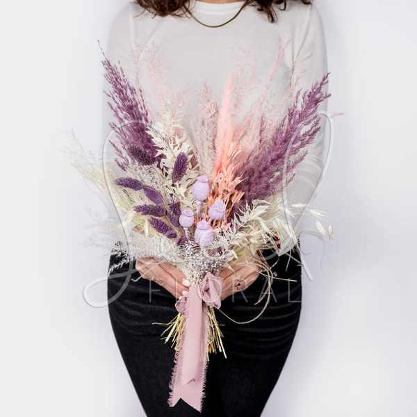 Bouquet of dried pink and purple grasses tied with a ribbon