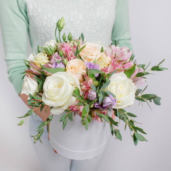 Handheld bouquet of white and pastel roses with pink alstroemeria