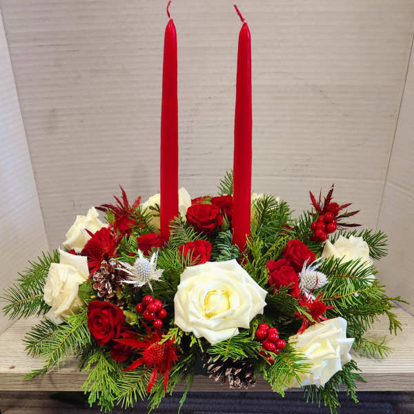 Red candles in a holiday arrangement of red and white roses