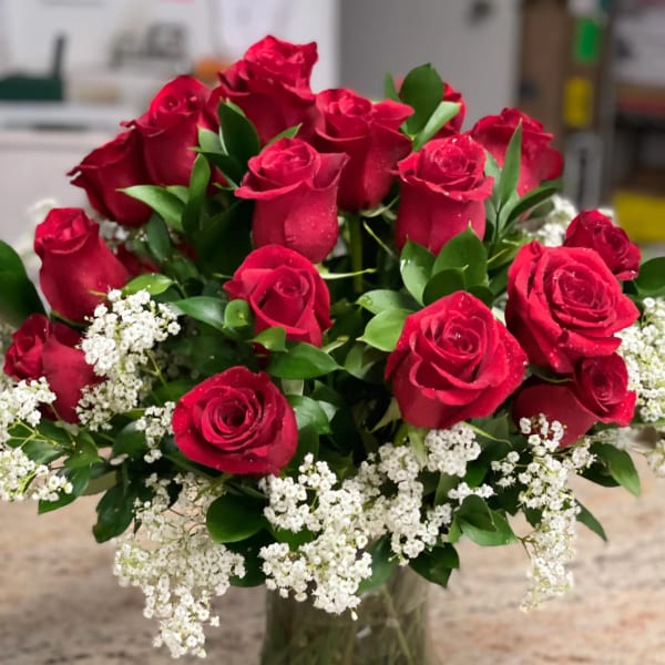 Bouquet of red roses and white baby's breath in a glass vase