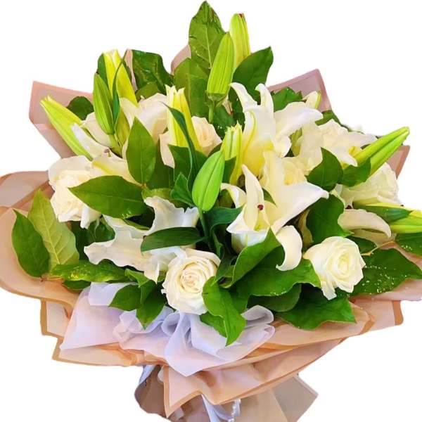 Bouquet of white lilies and roses wrapped in pale paper