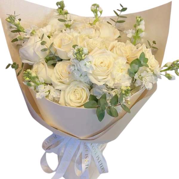 Bouquet of white roses and pale blooms wrapped in beige paper