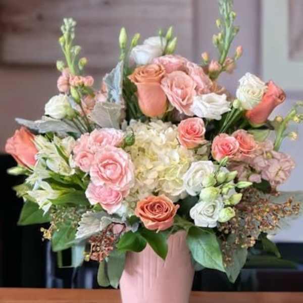 Pink and white rose bouquet in a pink vase