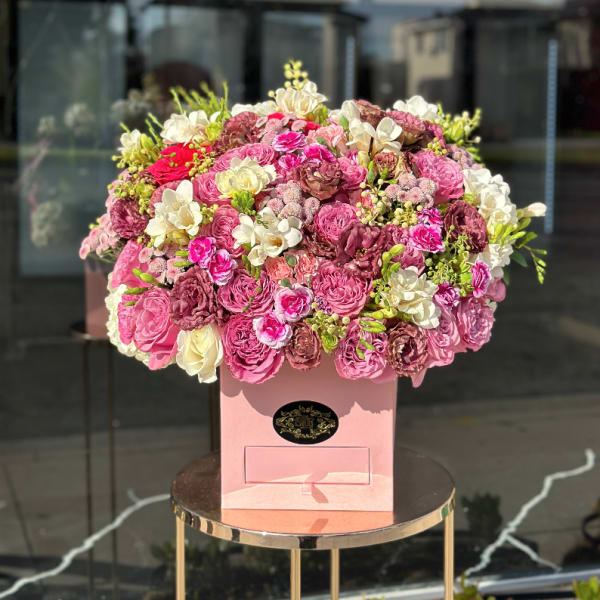Large pink and white rose arrangement in a pink box