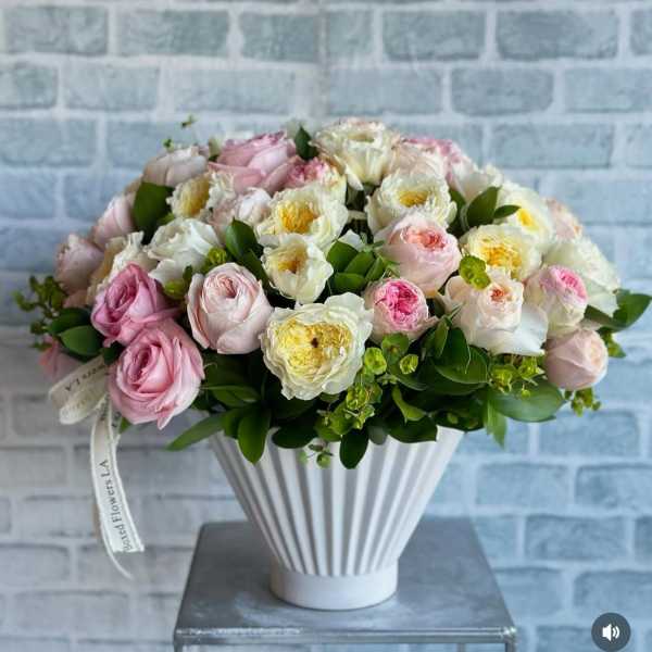Pink and white rose bouquet in a white ribbed vase