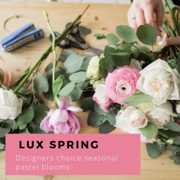 Pastel flower stems with pink and white blooms on a wooden table