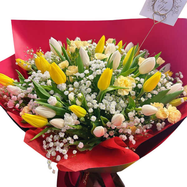 Bouquet of yellow and white tulips with baby's breath in red wrapping