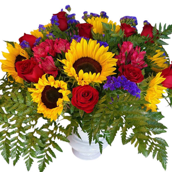 Bouquet of red roses, sunflowers, and purple filler in a white vase