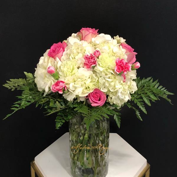 Pink and white floral arrangement in a clear glass vase