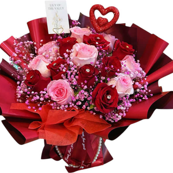Bouquet of red and pink roses with a heart topper and red wrapping