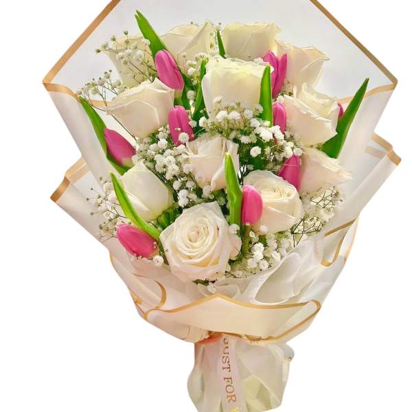 Bouquet of white roses and pink tulips wrapped in cream paper