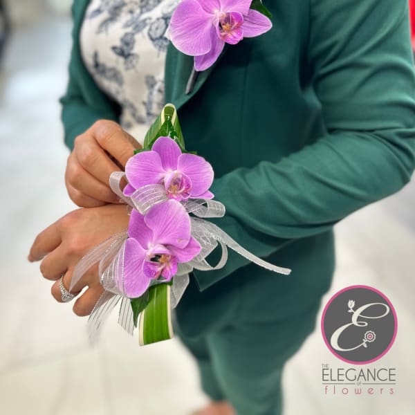 Purple orchid corsage with silver ribbon on a wrist
