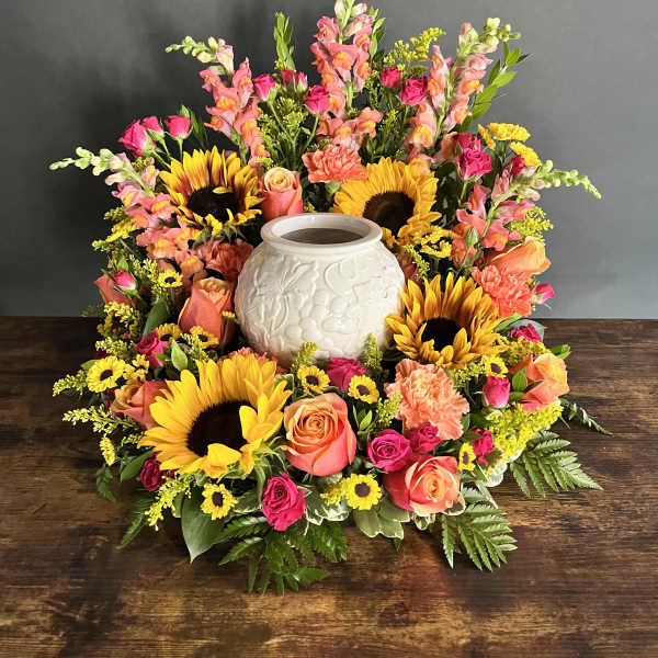 Colorful floral wreath around a white ceramic urn