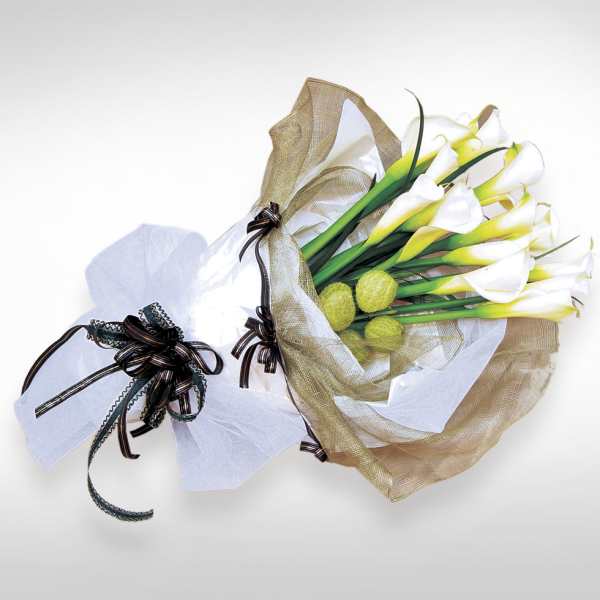 Bouquet of white calla lilies wrapped in tan and white paper