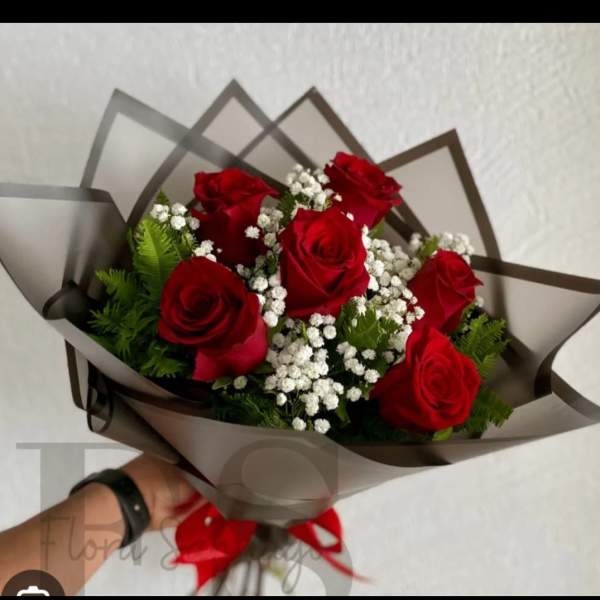 Bouquet of red roses with white baby's breath in dark wrap