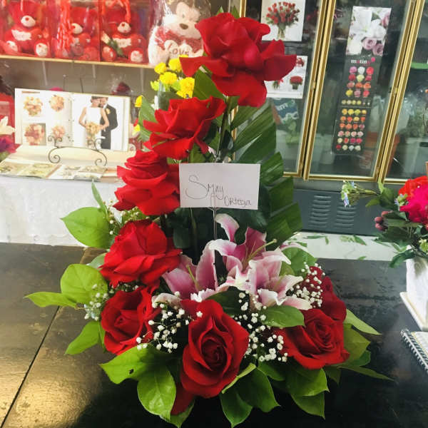 Tall arrangement of red roses and pink lilies with greenery