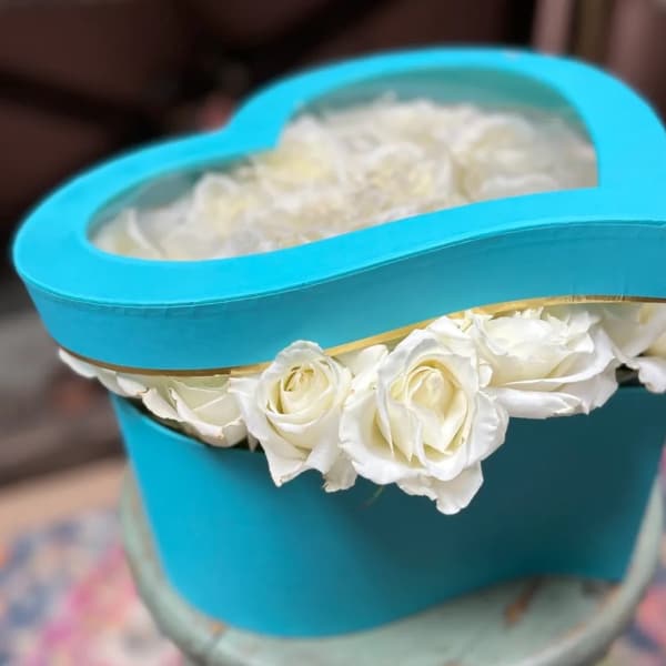 White roses in a turquoise heart-shaped box