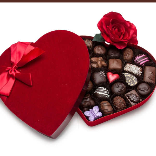 Heart-shaped box of assorted chocolates with a red ribbon and rose decoration