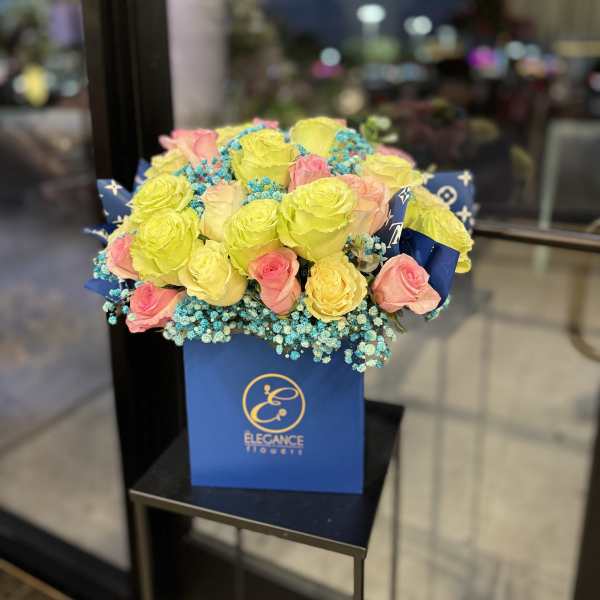 Bouquet of yellow and pink roses in a blue gift box