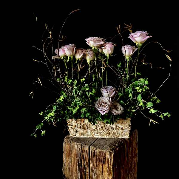 Arrangement of pale pink roses in a textured rectangular container
