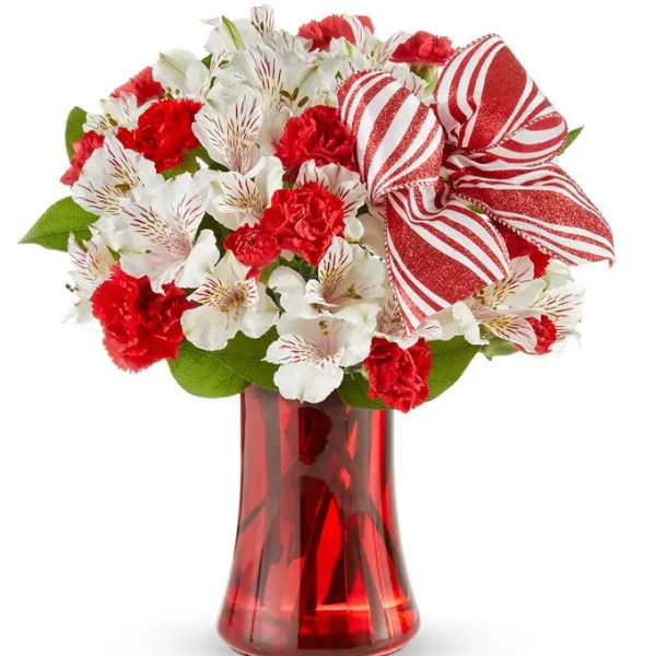 Red and white bouquet in a red glass vase with a striped bow