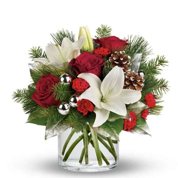 Red roses and white lilies in a glass vase with pinecones
