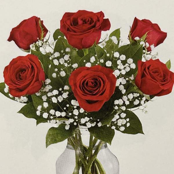 Bouquet of red roses with baby's breath in a clear glass vase