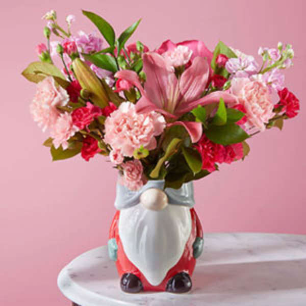 Pink floral arrangement in a Santa-shaped ceramic vase